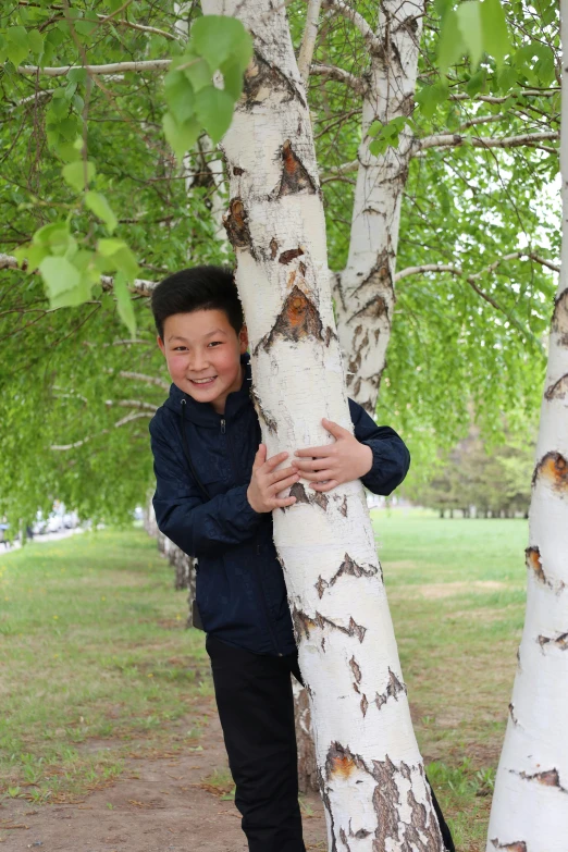 a  holding his arm around a tree