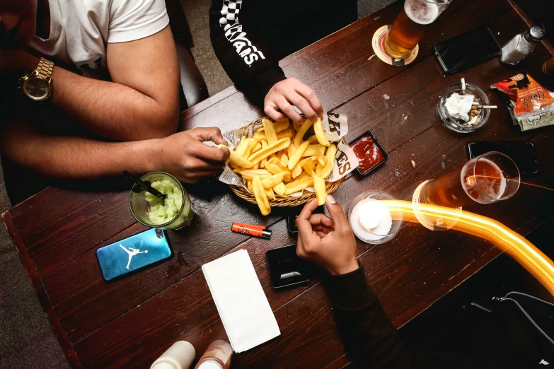 a group of people eating some food in a bowl on a table