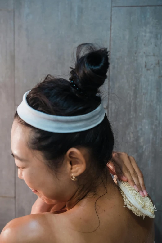 a woman in a bathing cap with a brush on her shoulder