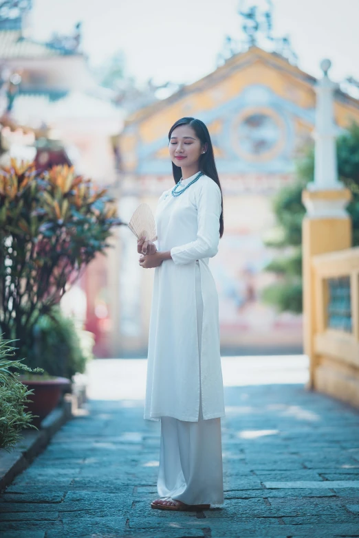 an asian woman standing in a street in front of a gazebo