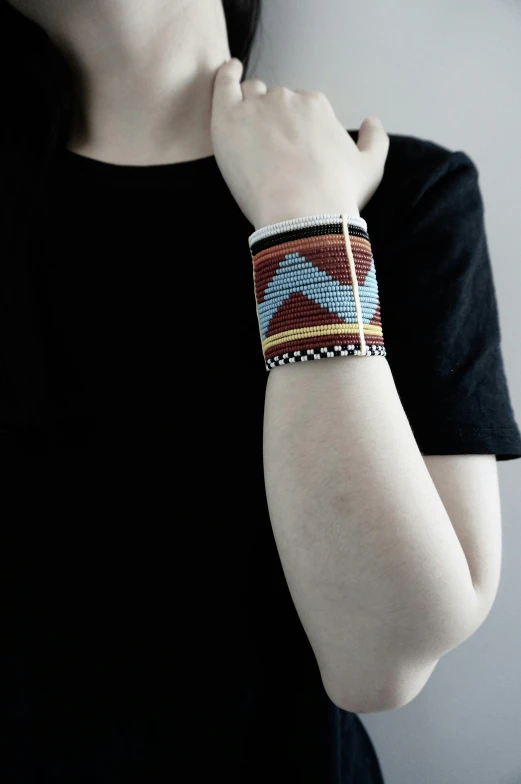 a woman in black shirt wearing a beaded celet