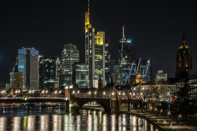 night time city scene with light on the buildings and river lights reflecting off the water