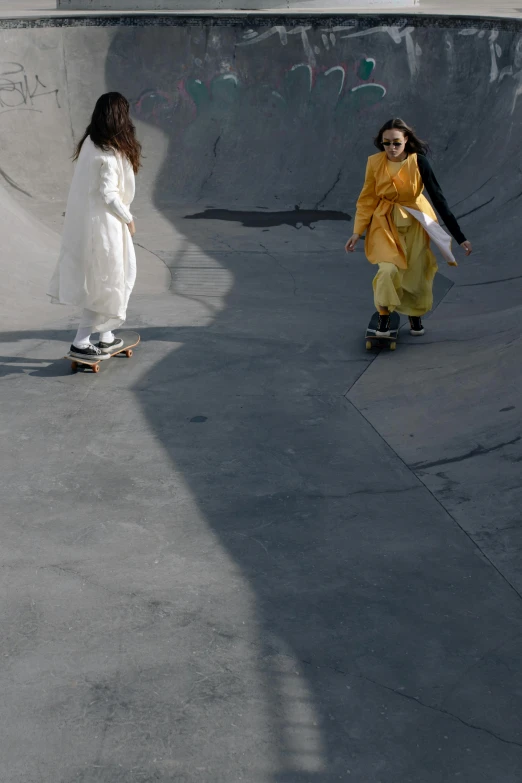 two people are standing at the skateboard park