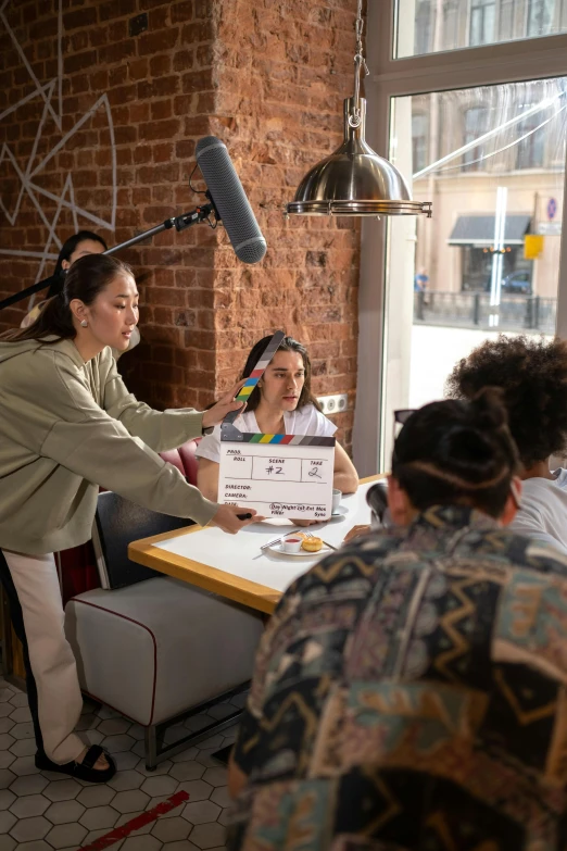 women are standing and sitting around a table