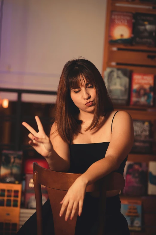 a woman seated and gesturing in a chair