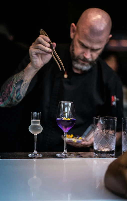 a man sitting at a table with several glasses in front of him