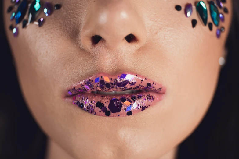 a woman with bright pink lips, makeup and accessories on her face