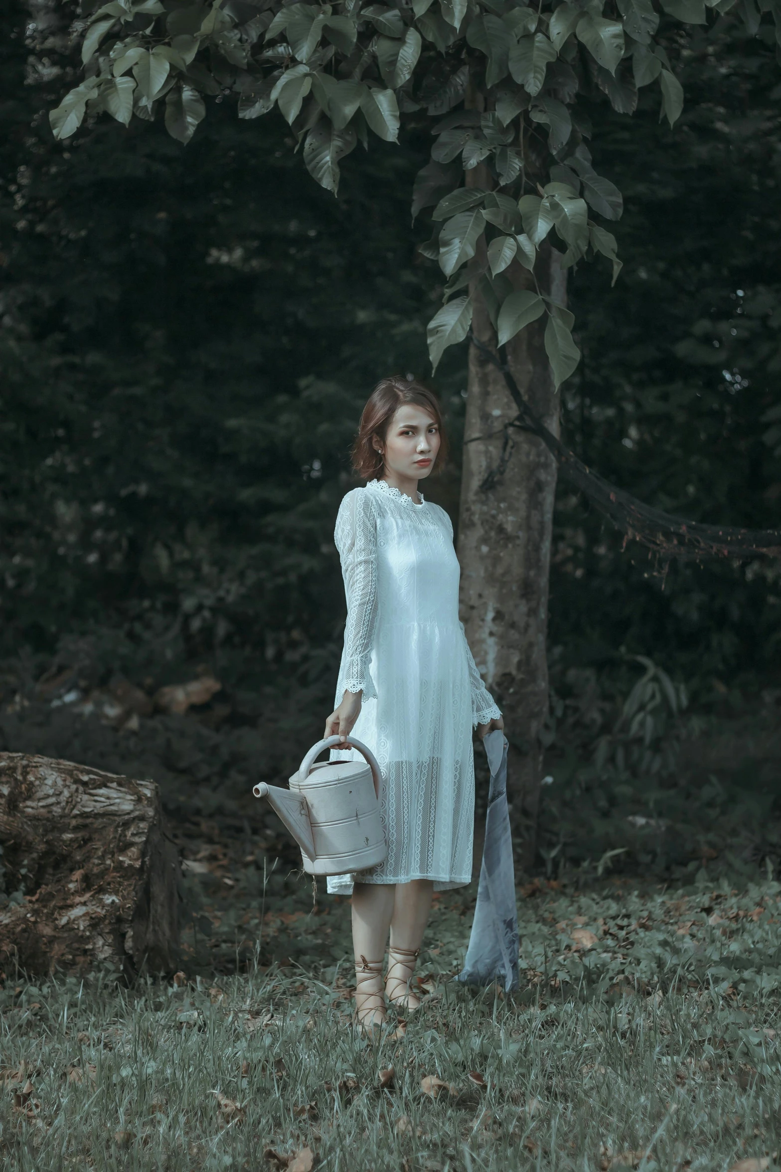 a woman with a bucket and some sort of jacket stands in the grass