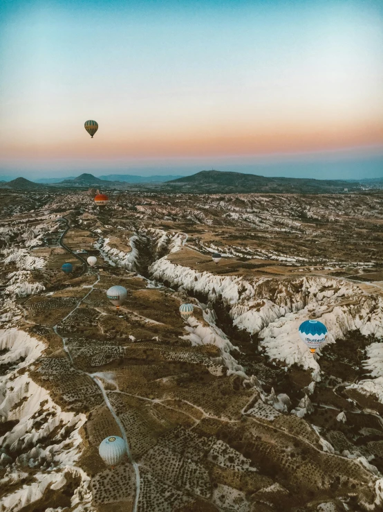 an overhead view of snow covered hills, a  air balloon flying in the sky