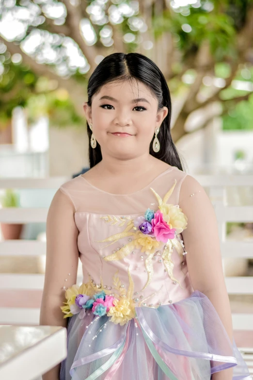 a girl dressed in a dress smiling for the camera