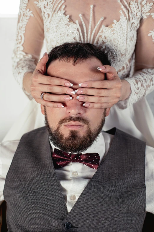 a couple holding their faces and covering their eyes