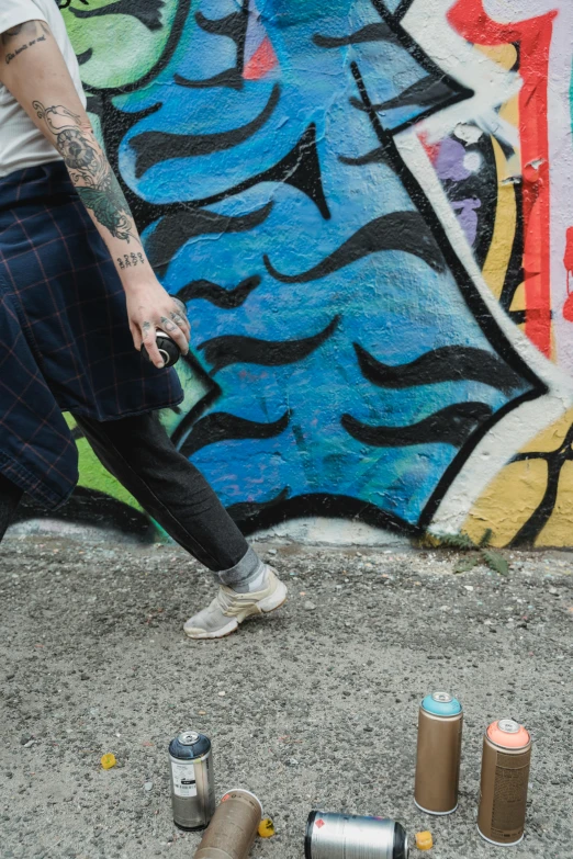 a man standing next to cans of paint