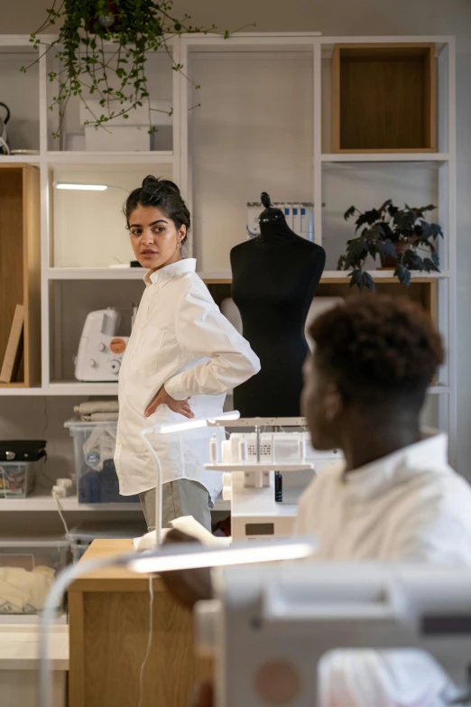 a man wearing a white lab coat standing next to a woman in a kitchen