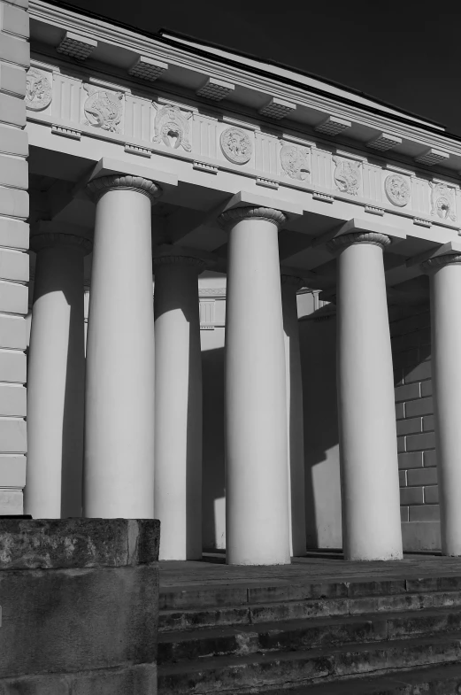 a view of the side of the building, with stone pillars in front