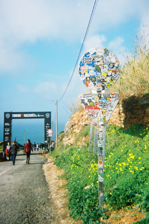 a sign post with street names on it sitting by the side of a dirt road