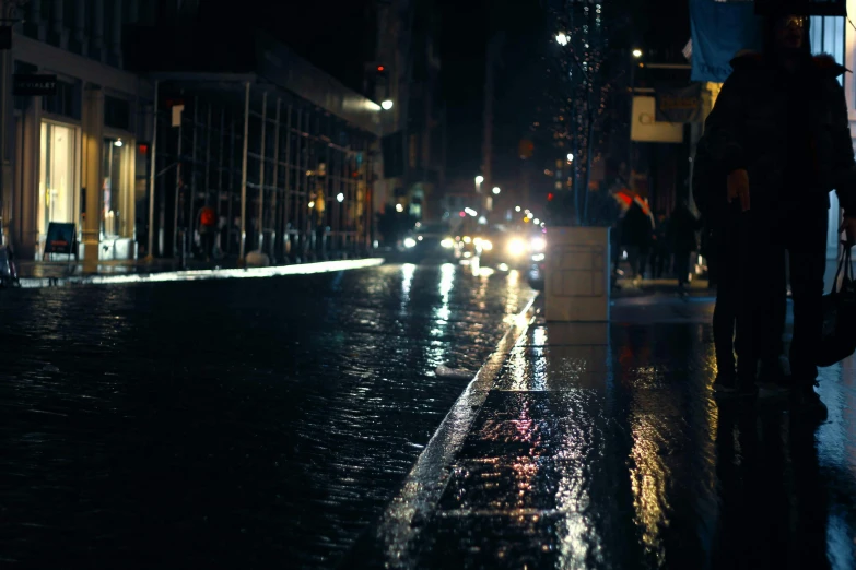 a city street at night with some cars driving on the road