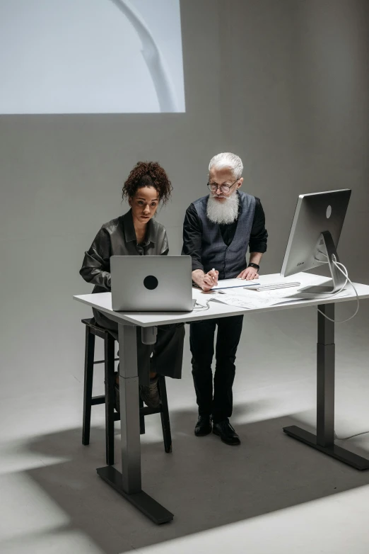 a couple looking at a computer screen on a table