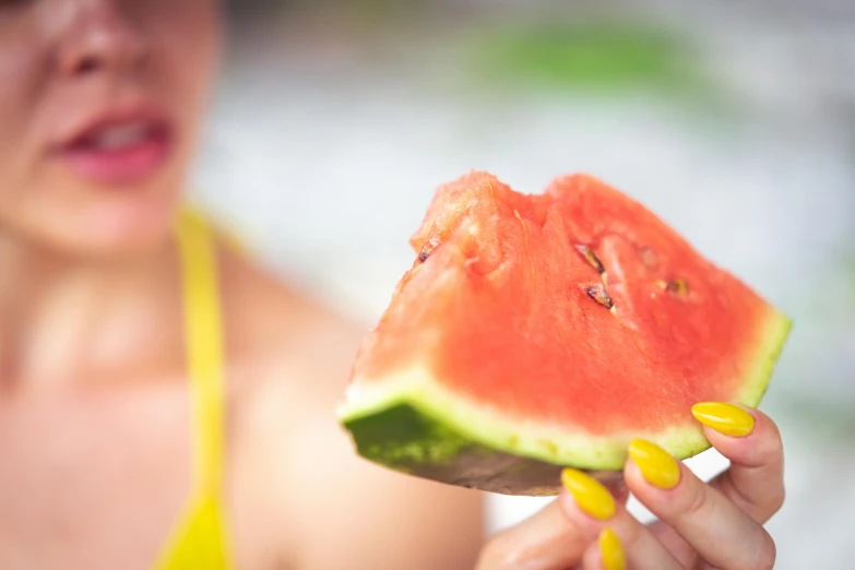 woman holding piece of watermelon in both hands