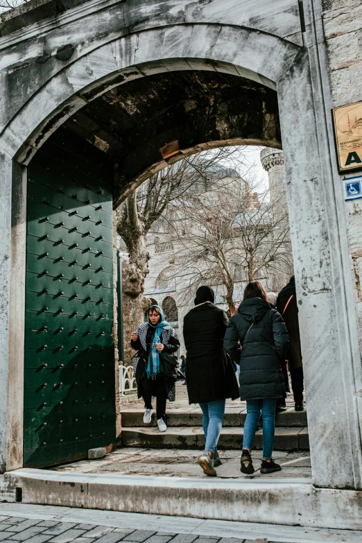 people walking up and down the stairs through an arched doorway