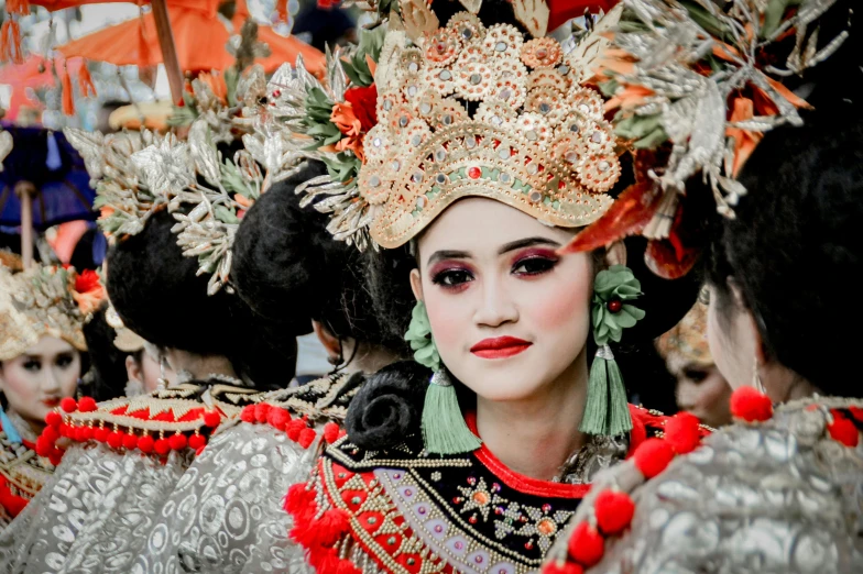 a woman in elaborate clothing standing next to another woman