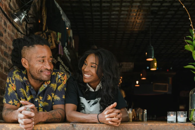 a man and woman smiling while sitting at a table