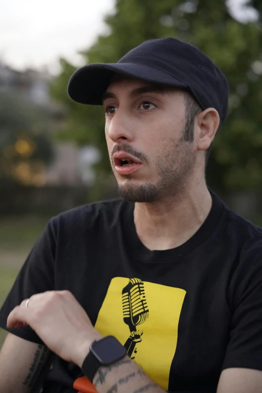 the man is wearing a cap and sitting down