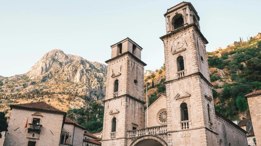 a cathedral with towers on a cliff side