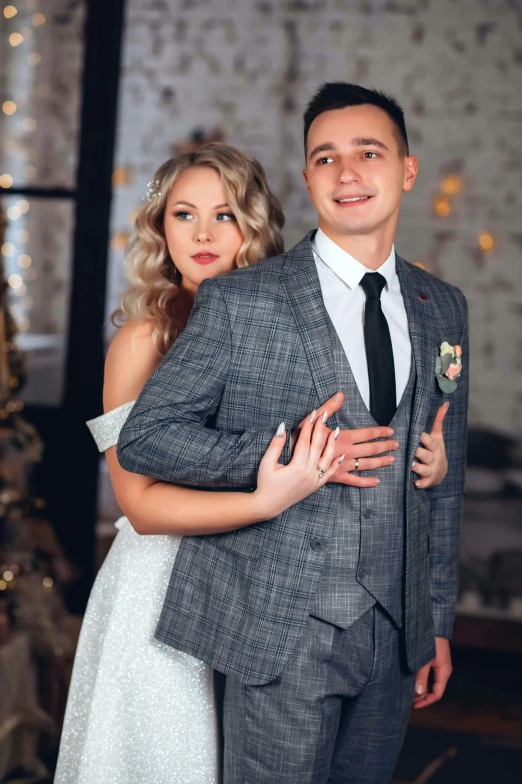 an engaged couple posing for a po in front of a christmas tree