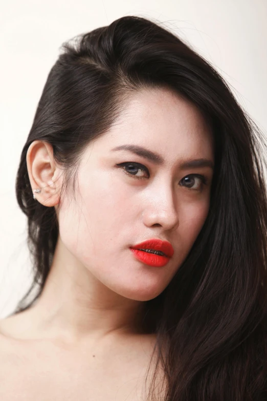 the girl is wearing red lipstick, posing for a po