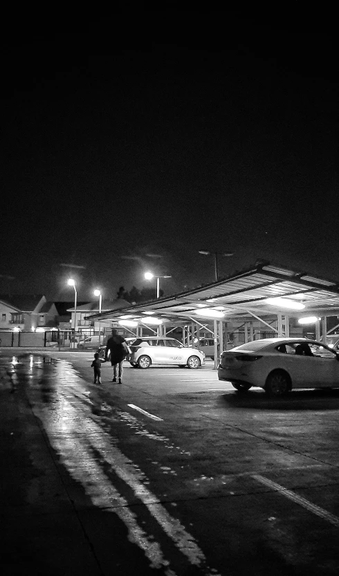 a person is walking into a parking lot at night