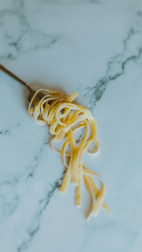 some noodles are being tossed onto a spoon