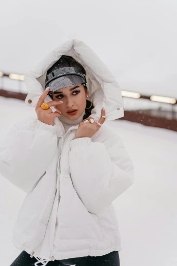 a woman wearing white is posing in the snow
