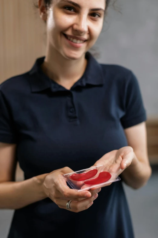 a woman holding an item in her hand, in the center of her po