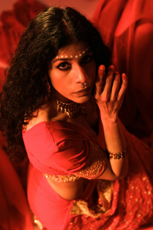 a young woman posing in a red sari