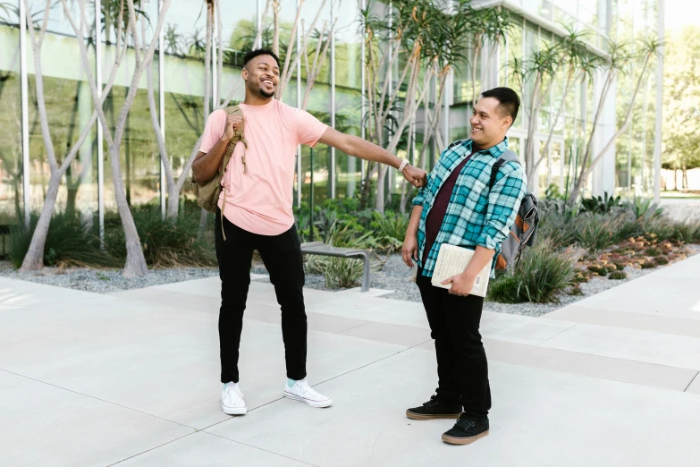 two men in casual clothes hold out their arms