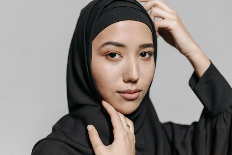 a person wearing a hijab on a grey background