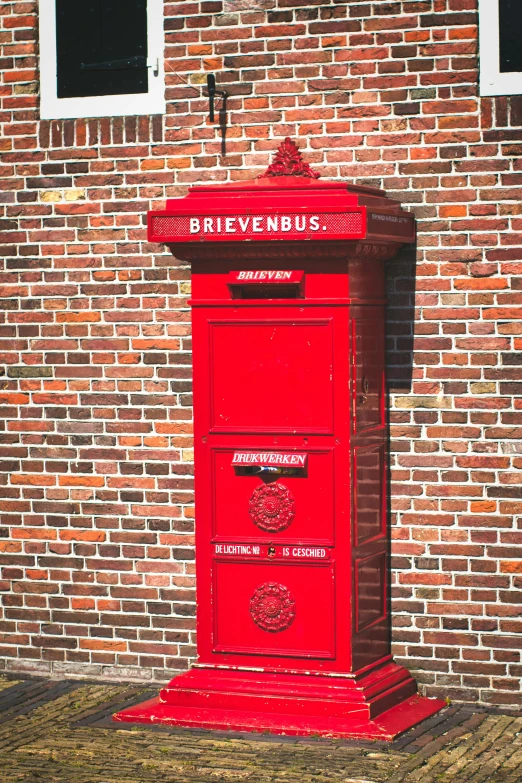 an old fashioned red letter box on the side of a building
