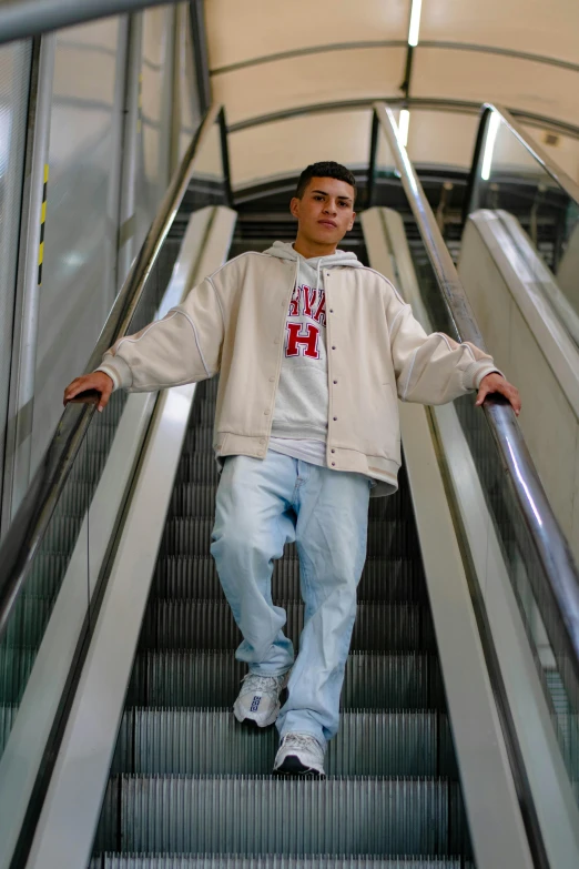 man standing on an escalator while wearing an adidas jacket