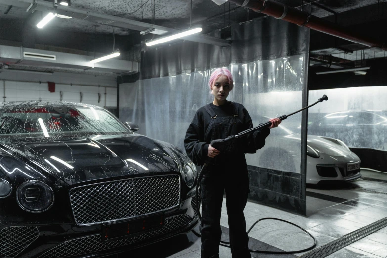 a woman holding a machine as a car in the background