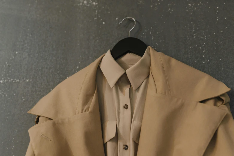 a tan coat hanging on a black hanger