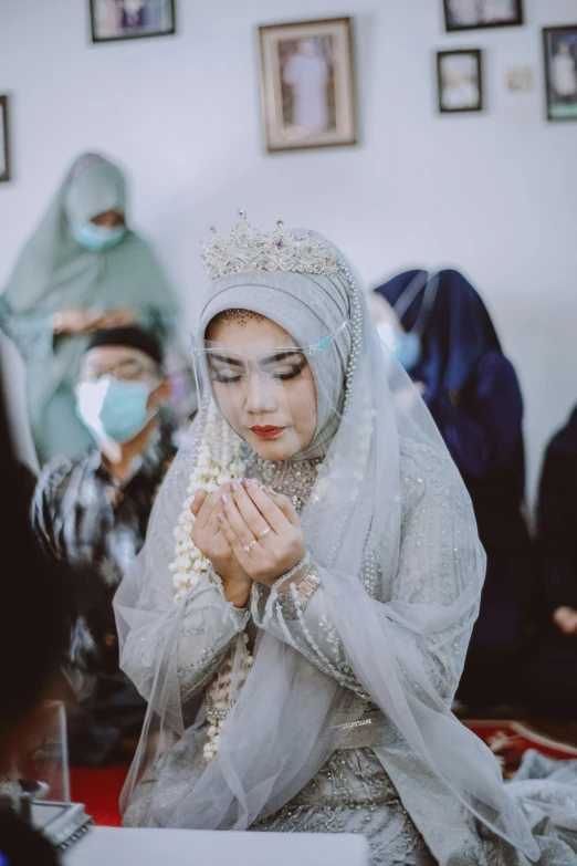 a girl in a veil sits on the floor