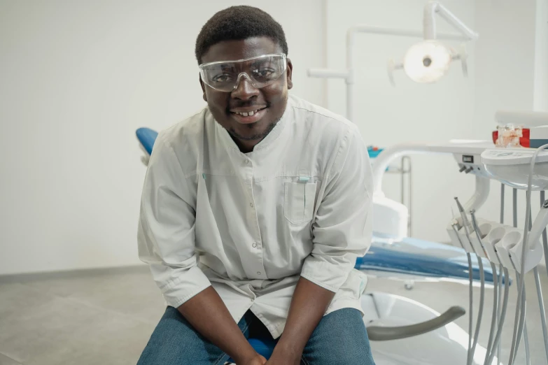 a man sits on a stool in the dentist's room