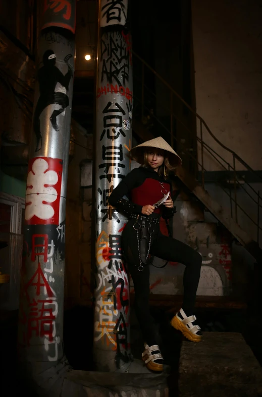 a girl posing for a picture next to a large pole