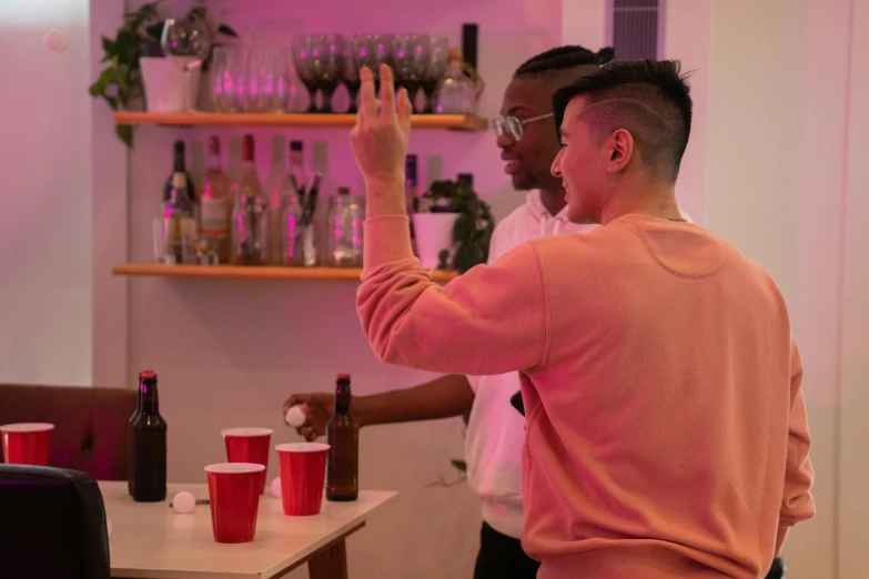 two men are drinking with cups of different types