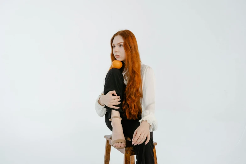 a woman sitting on a chair next to a brown object