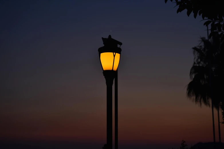 an image of an illuminated street lamp in a dusk