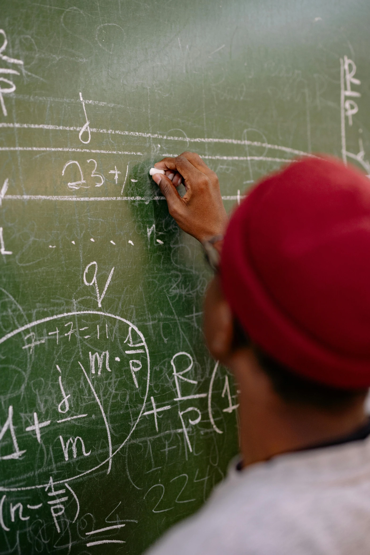 a man writing on a blackboard with numbers and symbols