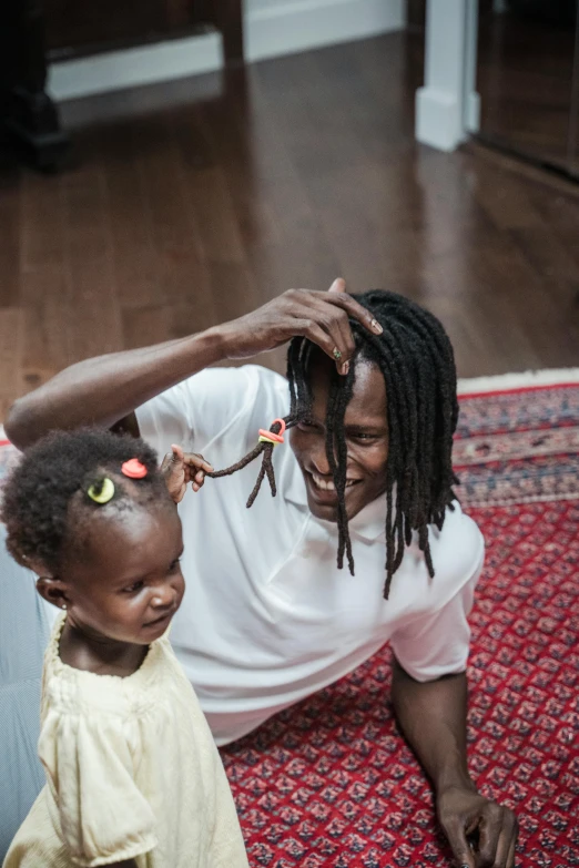 a woman putting a hair brush on her head next to a child