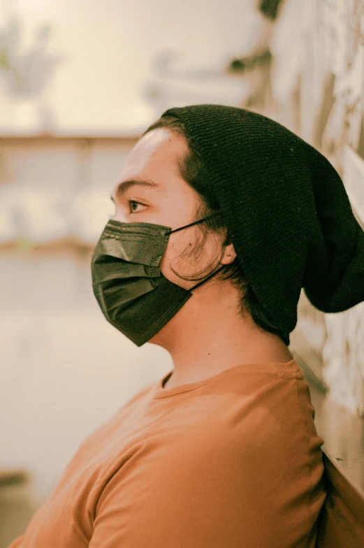 a man wearing a surgical face mask on his head