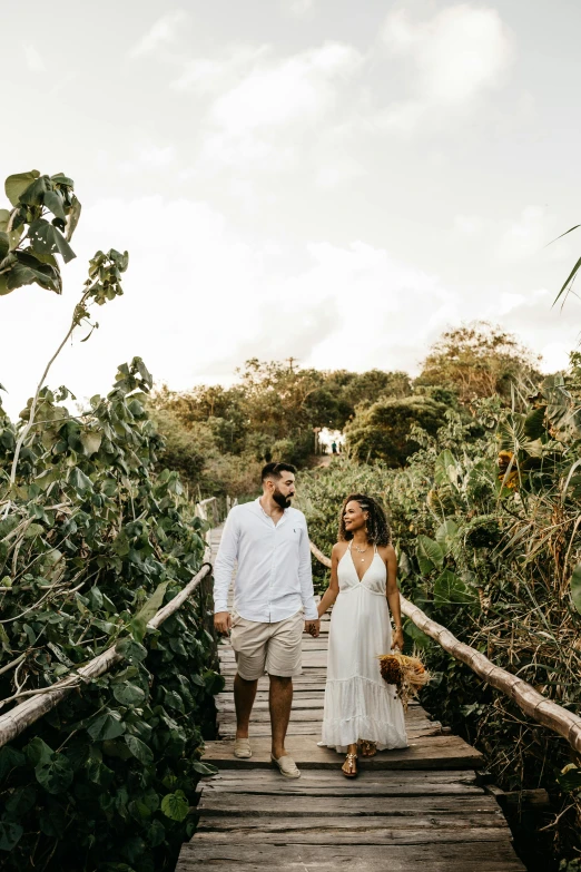 a couple is walking down a bridge together